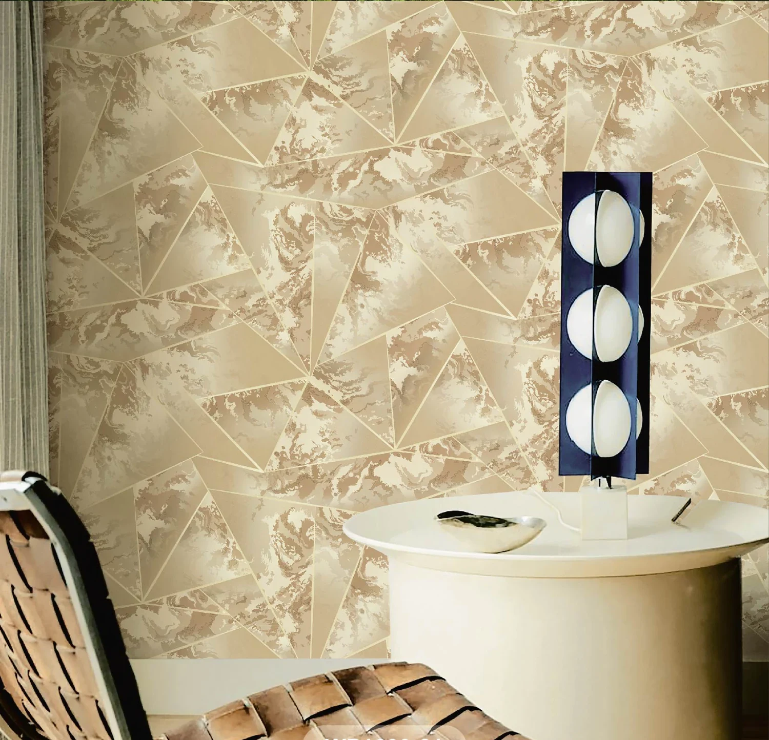 Beige faceted geode-pattern wallpaper behind a woven leather chair and a round side table