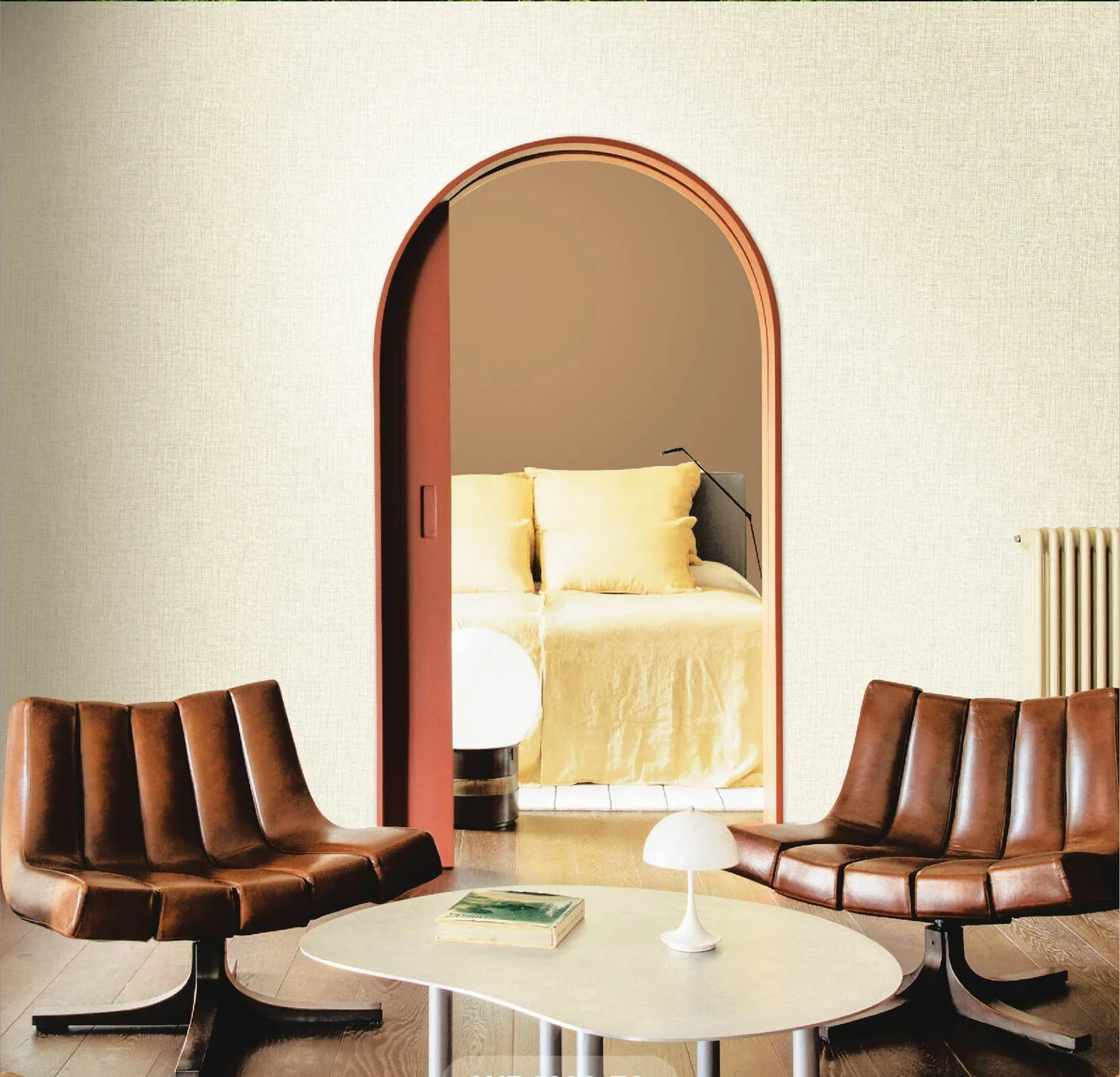 Arched alcove papered in a warm plain, with tan leather chairs in front of it