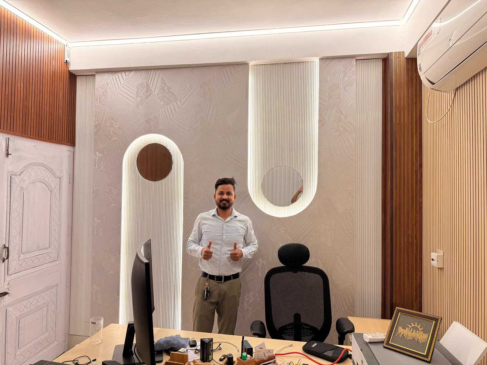 A finished office cabin in Guwahati with two backlit arched fluted panels holding round mirrors