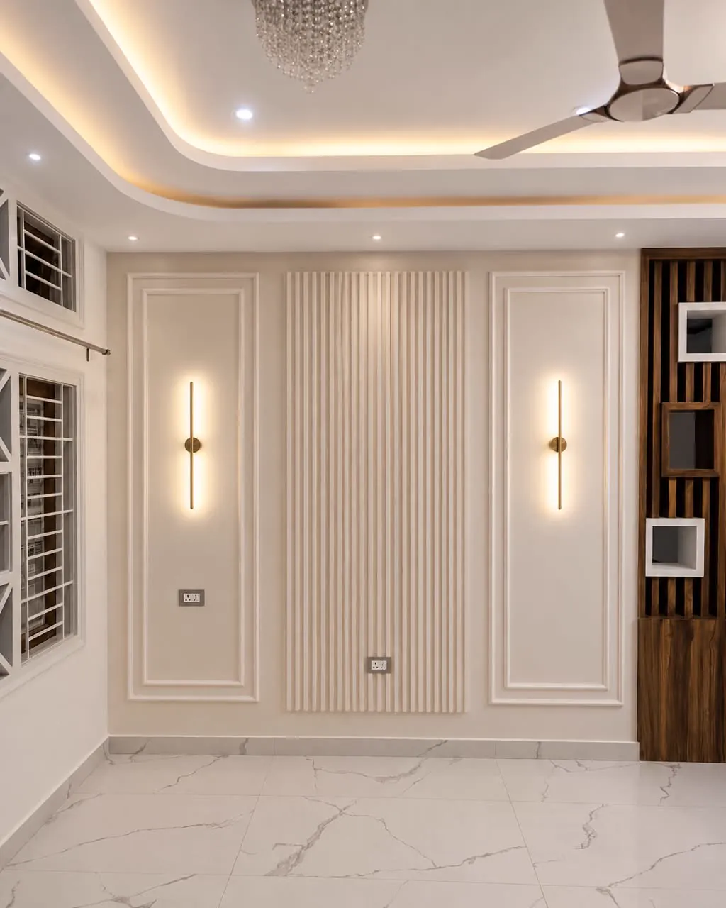 Beige fluted panel between two framed PU mouldings with slim brass wall lights, marble floor
